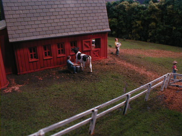 milking a cow by dairy barn ho scale model